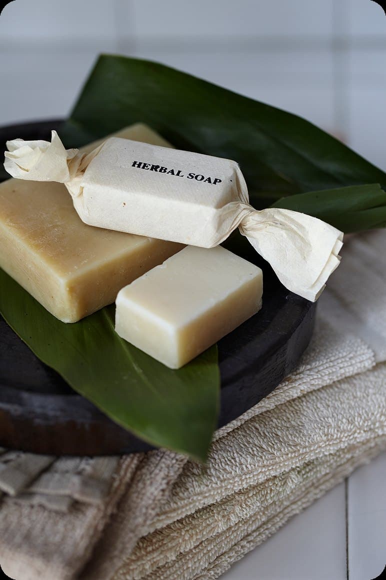 Herbal soap bars arranged on green leaves