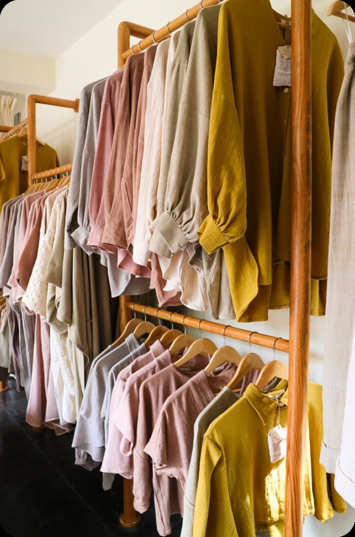Natural-fibre clothing hanging on wooden racks