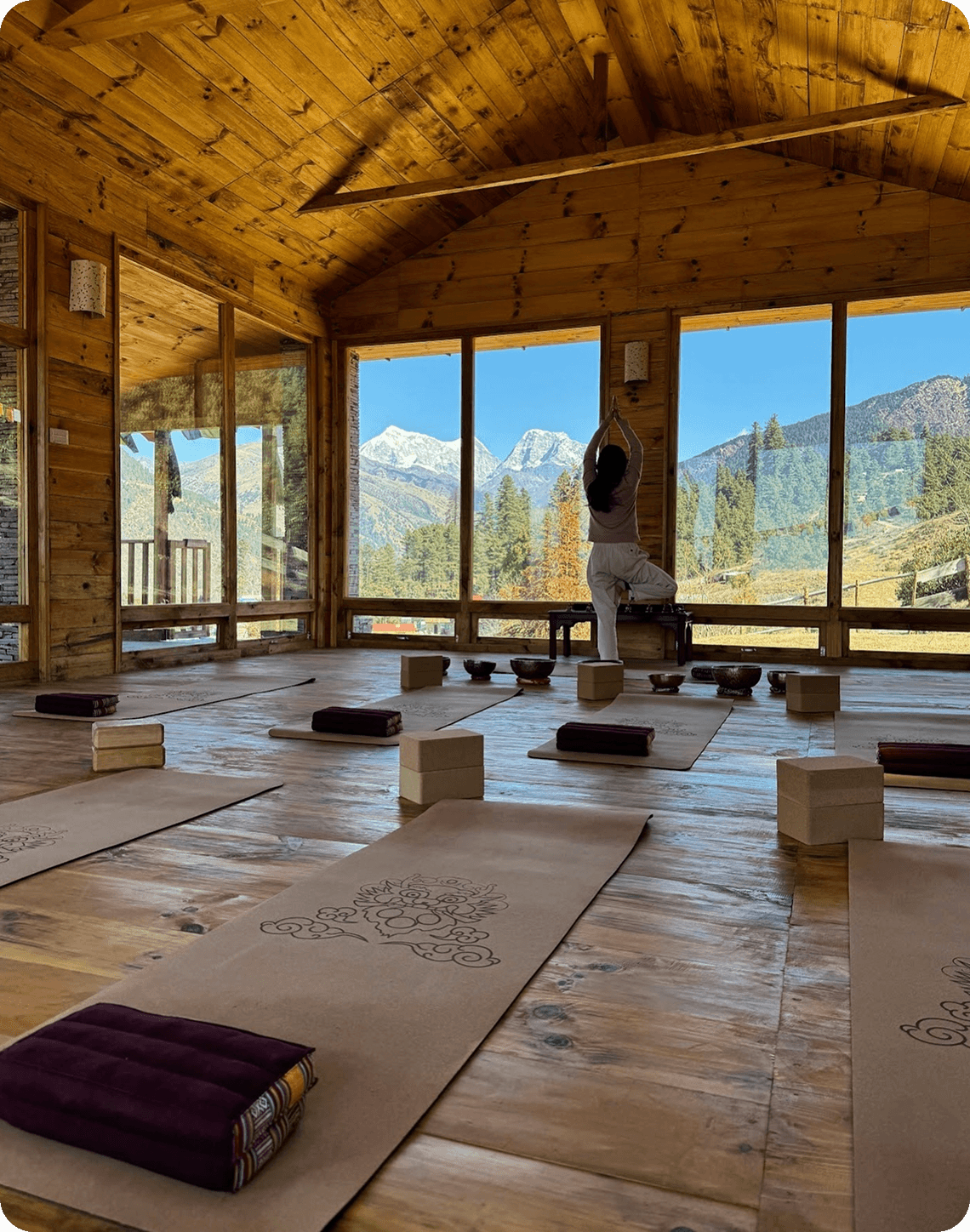 Yoga practice in a wood studio facing the mountains